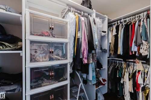 Walk-in closet featuring extensive built-in shelving, multiple hanging rods, and integrated storage units - 3412 Macneil Link, Edmonton, AB 