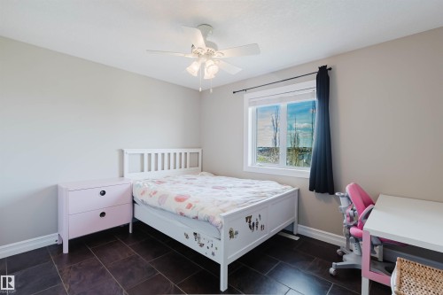 Room featuring dark tile flooring, neutral wall paint, and a white ceiling fan with integrated lighting - 3412 Macneil Link, Edmonton, AB 