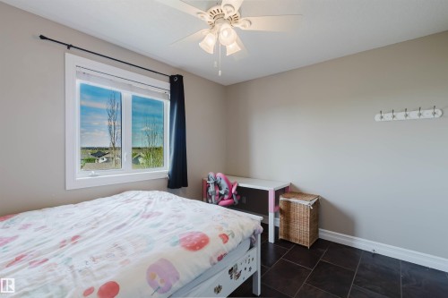 Room featuring dark tile flooring, neutral wall paint, and a white ceiling fan with light fixture - 3412 Macneil Link, Edmonton, AB 