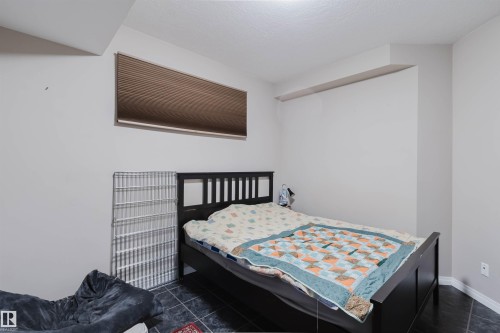 Room with dark tile flooring, white walls, and a single horizontal window with brown blinds - 3412 Macneil Link, Edmonton, AB 