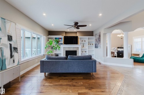 Spacious living area featuring wood-finish flooring, recessed lighting, and a ceiling fan - 3412 Macneil Link, Edmonton, AB 