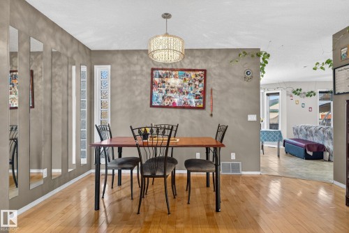 Dining area featuring wood-finish flooring and a contemporary chandelier - 3912 31 Street, Edmonton, AB 