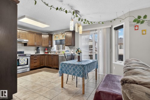 Kitchen featuring wood-finish cabinetry, stainless steel appliances, and a subway tile backsplash - 3912 31 Street, Edmonton, AB 