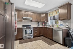 Kitchen featuring wood cabinetry, stainless steel appliances, granite-style countertops, subway tile backsplash, and tile flooring - 