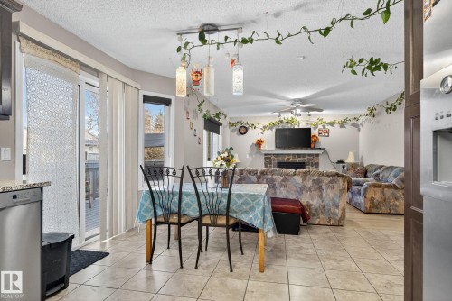 Tiled flooring extends through this dining area, featuring a linear chandelier - 3912 31 Street, Edmonton, AB 