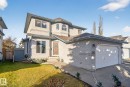 Two-story stucco residence featuring an integrated garage, a concrete driveway, and a fenced side yard - 3912 31 Street, Edmonton, AB 