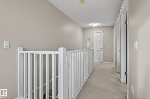 Upper level hallway featuring light gray wall paint and light neutral carpeting - 3912 31 Street, Edmonton, AB 