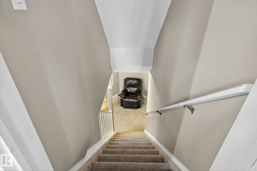 Carpeted staircase with white balusters leading to a carpeted landing - 3912 31 Street, Edmonton, AB 