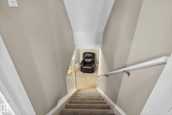 Carpeted staircase with white balusters leading to a carpeted landing - 