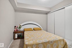 Bedroom featuring neutral wall paint, carpet flooring, a built-in closet with sliding doors, and a ceiling-mounted light fixture - 