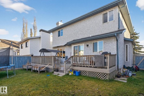 Two-story stucco exterior with a multi-level wood deck, accessible via sliding glass doors - 3912 31 Street, Edmonton, AB 