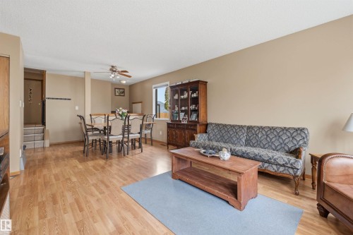 Open-concept living and dining areas featuring wood-finish flooring, neutral wall tones, and recessed lighting - 18648 57 Avenue, Edmonton, AB - Indoor Photo Showing Living Room