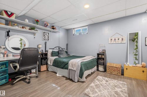 Room featuring wood-finish flooring, drop ceiling with recessed lighting, and a horizontal window - 18648 57 Avenue, Edmonton, AB - Indoor Photo Showing Bedroom