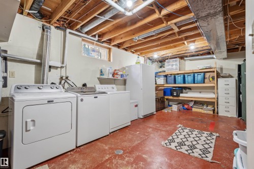 Utility space featuring an exposed wood ceiling, painted concrete flooring, and a small transom window - 18648 57 Avenue, Edmonton, AB - Indoor Photo Showing Laundry Room