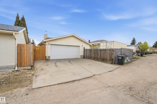 Detached garage with a single overhead door, concrete driveway, and wood fencing - 18648 57 Avenue, Edmonton, AB - Outdoor With Exterior
