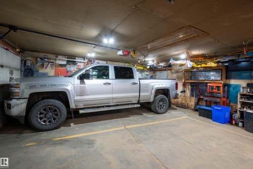 Spacious garage featuring concrete flooring and ample overhead lighting - 18648 57 Avenue, Edmonton, AB - Indoor Photo Showing Garage