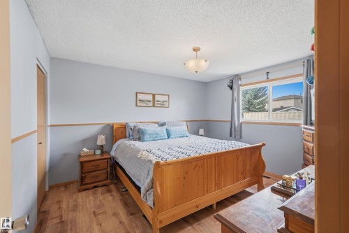 Bedroom featuring two-tone wall paint, wood-finish flooring, and a single window with a white frame - 18648 57 Avenue, Edmonton, AB - Indoor Photo Showing Bedroom