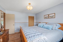 Bedroom featuring wood-finish flooring, two-tone wall treatment, and a semi-flush mount ceiling light fixture - 