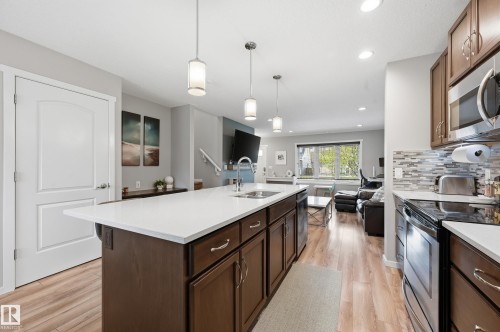 Kitchen island with white countertop, integrated sink, and pendant lighting - 3457 Cutler Crescent, Edmonton, AB - Indoor Photo Showing Kitchen With Upgraded Kitchen