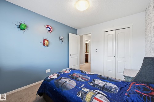 Neutral-toned carpet flooring and a light blue accent wall - 3457 Cutler Crescent, Edmonton, AB - Indoor Photo Showing Bedroom