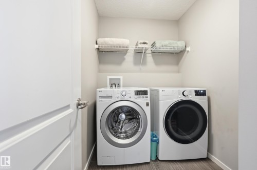 Dedicated laundry area featuring a front-loading washer and dryer set - 3457 Cutler Crescent, Edmonton, AB - Indoor Photo Showing Laundry Room