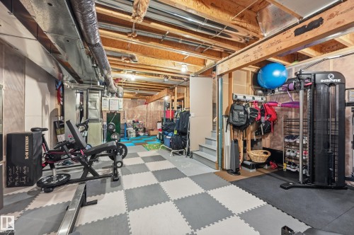 Finished basement area featuring exposed ceiling joists and ductwork, checkerboard foam flooring, partial drywall, and exposed wood framing - 3457 Cutler Crescent, Edmonton, AB - Indoor Photo Showing Basement