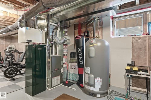 Basement utility area featuring a water heater, furnace, and exposed ductwork - 3457 Cutler Crescent, Edmonton, AB - Indoor Photo Showing Basement