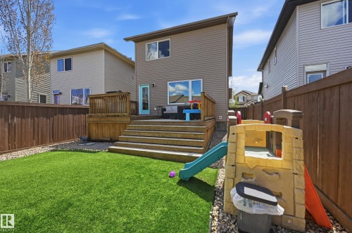 Expansive backyard featuring artificial turf, a multi-tiered wood deck with privacy screening, and a full-height privacy fence - 3457 Cutler Crescent, Edmonton, AB - Outdoor With Deck Patio Veranda With Exterior