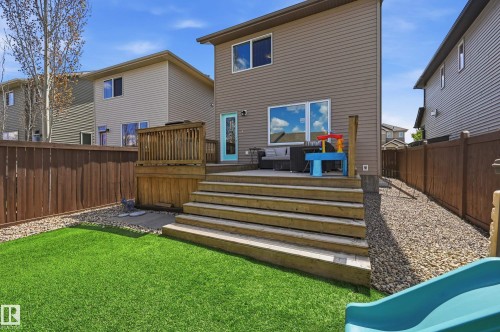 Spacious backyard featuring a multi-level wood deck, artificial turf lawn, and surrounding gravel landscaping - 3457 Cutler Crescent, Edmonton, AB - Outdoor With Exterior