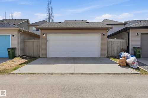 Single-stall garage with a white panel door and exterior sconce lighting - 3457 Cutler Crescent, Edmonton, AB - Outdoor With Exterior