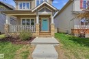Inviting front facade featuring a covered porch with a white railing system, two-story construction, light-toned siding, and a vibrant turquoise entry door - 3457 Cutler Crescent, Edmonton, AB  - Outdoor With Deck Patio Veranda With Facade 