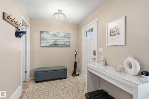 Inviting entryway featuring a paneled door with glass insert, light wood-finish flooring, a flush-mount ceiling light fixture, and neutral wall tones - 3457 Cutler Crescent, Edmonton, AB - Indoor