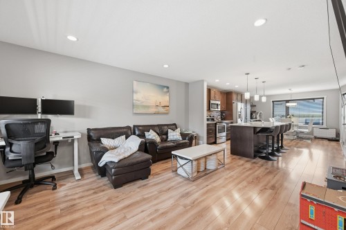 Open-concept living area featuring wood-finish flooring, recessed lighting, and a kitchen with an island - 3457 Cutler Crescent, Edmonton, AB - Indoor Photo Showing Living Room