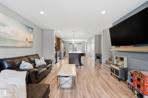Open-concept living space featuring wood-finish flooring, recessed lighting, and a neutral color palette - 3457 Cutler Crescent, Edmonton, AB - Indoor Photo Showing Living Room
