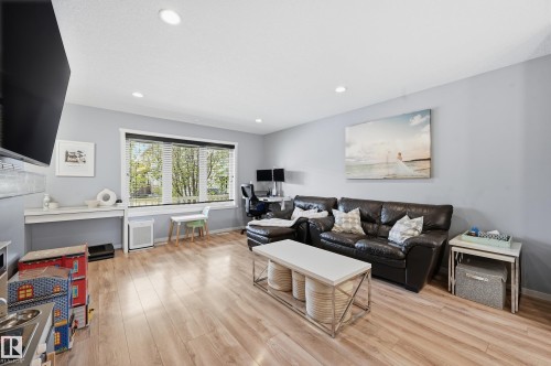 Bright living area featuring wood-finish flooring, recessed lighting, and light grey wall finishes - 3457 Cutler Crescent, Edmonton, AB - Indoor Photo Showing Living Room