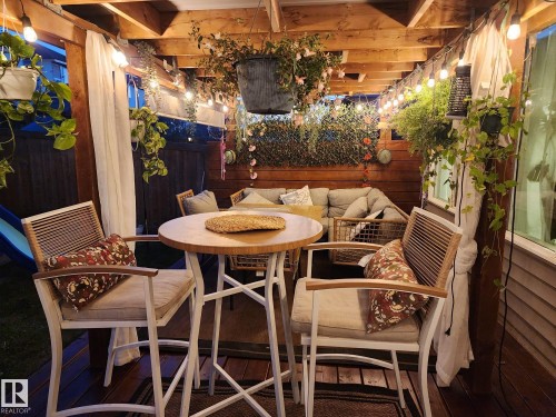 Wood-decked patio with a slatted wood ceiling, accented by string lighting - 22931 96 Avenue, Edmonton, AB - Indoor