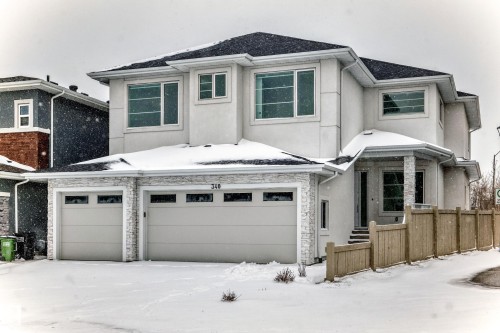 Modern exterior featuring a two-car garage with transom windows and stacked stone accents - 340 33 Ave, Edmonton, AB - Outdoor