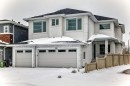 Modern exterior featuring a two-car garage with transom windows and stacked stone accents - 340 33 Ave, Edmonton, AB  - Outdoor 