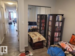 Mirrored closet doors providing visual depth, complemented by neutral wall paint and wood-finish flooring - 