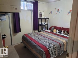 Room featuring light-colored walls and a window with purple drapes - 