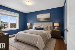 Spacious room featuring wood-finish flooring, a large window with white trim, and a contemporary ceiling light fixture - 