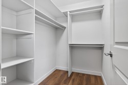 Customized closet system featuring multiple shelving units and clothing rods - 