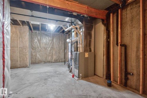 Unfinished basement with concrete flooring, exposed wood ceiling joists, and visible insulation - 11 450 Mcconachie Way, Edmonton, AB - Indoor Photo Showing Basement