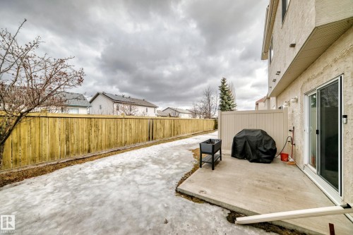 Private outdoor patio space featuring a sliding glass door entry, stucco exterior, and a privacy fence - 105 13825 155 Avenue, Edmonton, AB - Outdoor