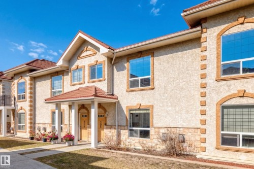 Stucco exterior with stone veneer accents and arched window frames - 105 13825 155 Avenue, Edmonton, AB - Outdoor