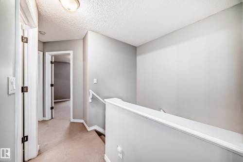 Hallway featuring neutral-toned walls, carpeted flooring, and white trim - 105 13825 155 Avenue, Edmonton, AB - Indoor Photo Showing Other Room