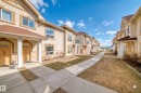 Row of stucco-finished townhomes with integrated stone accents - 105 13825 155 Avenue, Edmonton, AB  - Outdoor 