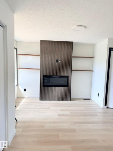 Integrated electric fireplace with a slatted wood-finish accent wall - 11628 151 Avenue Nw, Edmonton, AB 