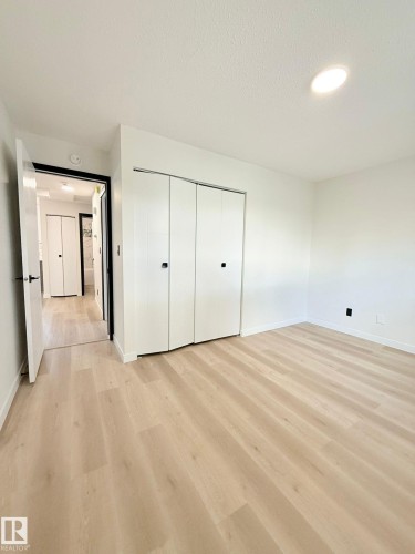 Light wood-finish flooring and white walls define this room - 11628 151 Avenue Nw, Edmonton, AB 
