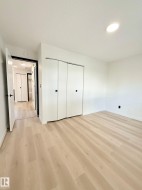 Light wood-finish flooring and white walls define this room - 